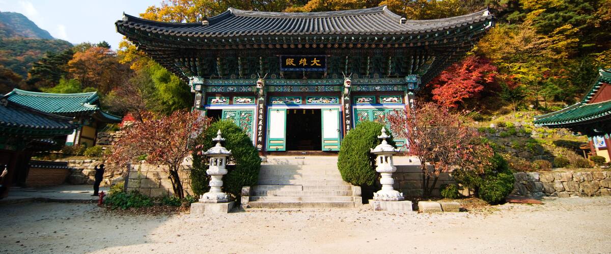 A traditional Korean gate with intricate designs and a signboard.