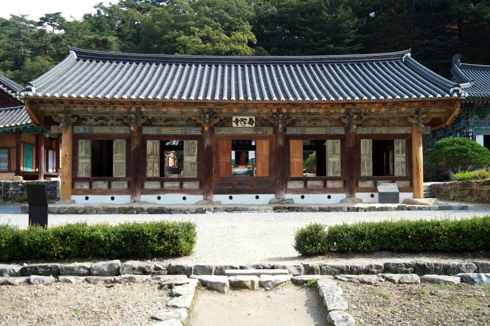 A traditional Korean building with a tiled roof and wooden columns.
