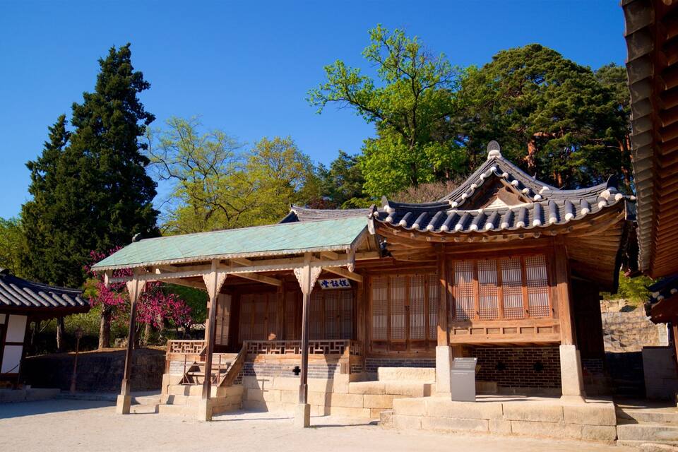 A traditional Korean pavilion with a tiled roof, surrounded by stone steps and lush greenery.