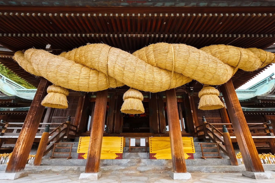 A traditional wooden structure with intricately woven ropes hanging from the ceiling.
