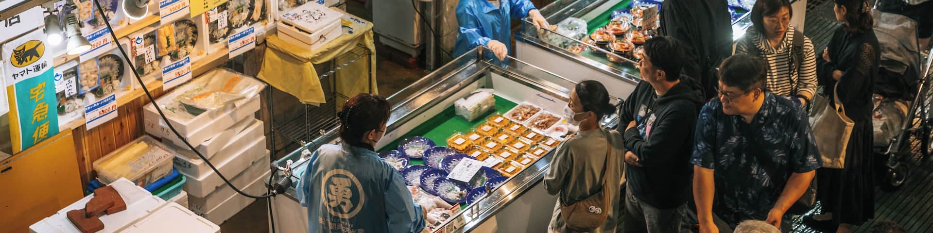 Un mercado animado con diversos puestos que exhiben mariscos y otros productos.