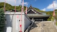 A traditional Japanese building with a sloped roof and a stone staircase leading up to it.