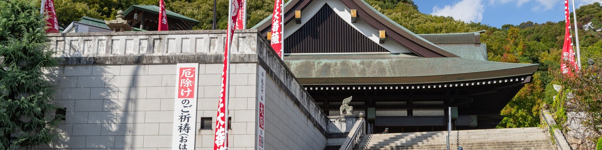 Un edificio tradicional japonés con techo inclinado y una escalera de piedra que lleva a la entrada.