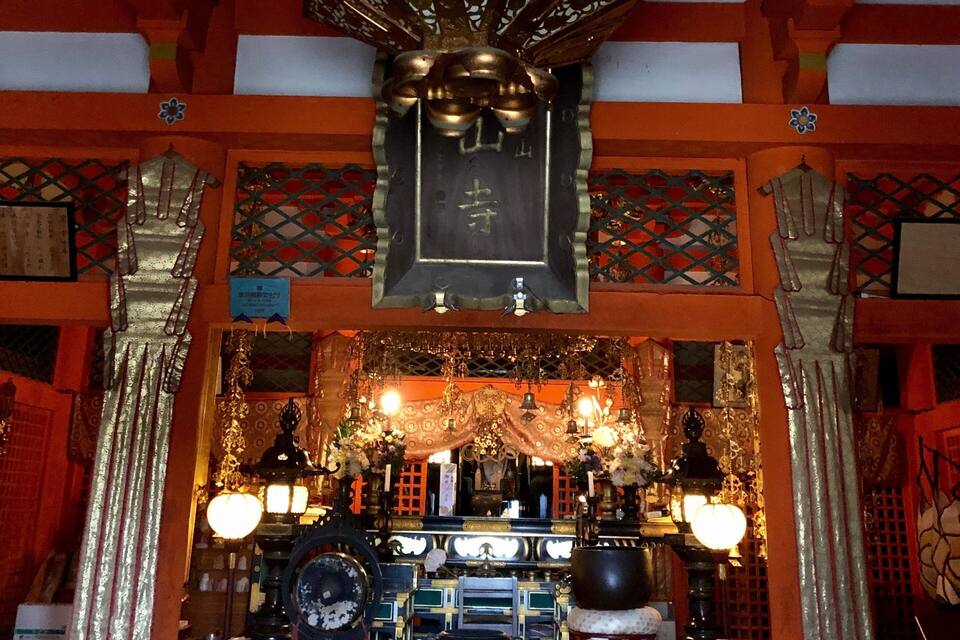 En traditionel japansk helligdom med overdådige udsmykninger, en gylden krone og diverse rituelle genstande.