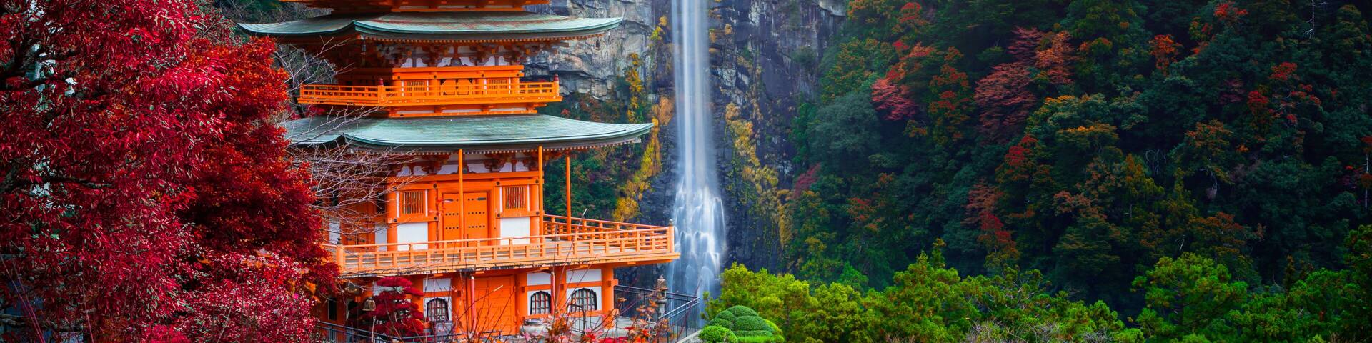 A multi-tiered pagoda with a waterfall in the background.