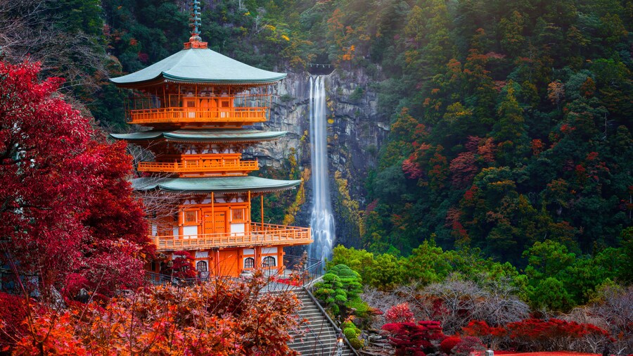 Kumano nachi taisha shrine with waterfalls along in view at season change of Autumn, the famous and popular tourist place in Kumano of Japan