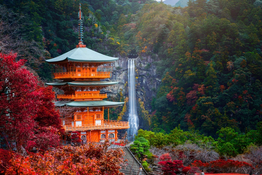 Kumano nachi taisha shrine with waterfalls along in view at season change of Autumn, the famous and popular tourist place in Kumano of Japan