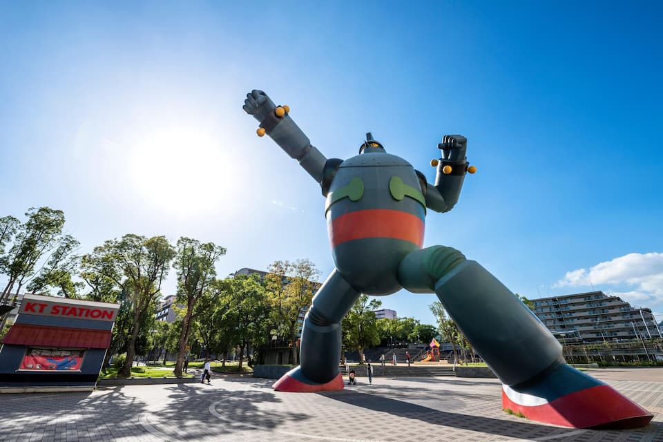 A large inflatable sculpture in a public square with a sign reading "KT Station" in the background.