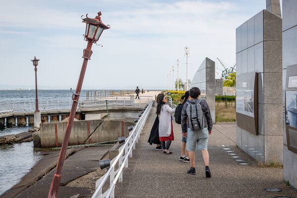 Port of Kobe Earthquake Memorial showing general coastal views as well as a small group of people