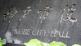 A stone plaque with Japanese characters and the English text "KOBE CITY HALL".