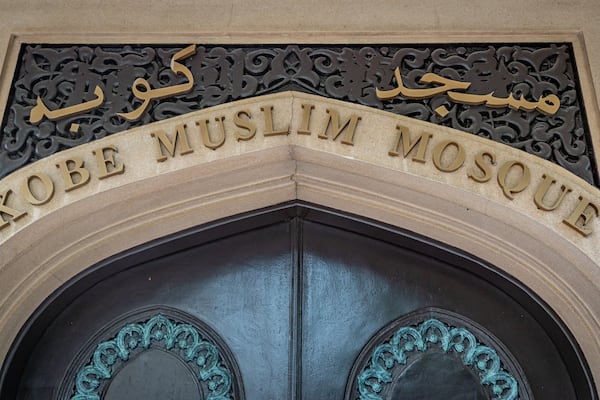 Eingang einer Moschee mit arabischer Kalligraphie und der Aufschrift 'KOBE MUSLIM MOSQUE' in englischer Sprache.