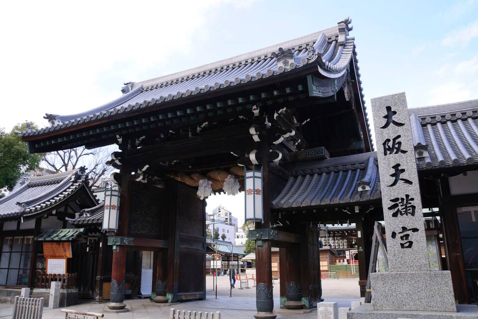 Traditional architecture with a prominent stone pillar and a tiled roof.