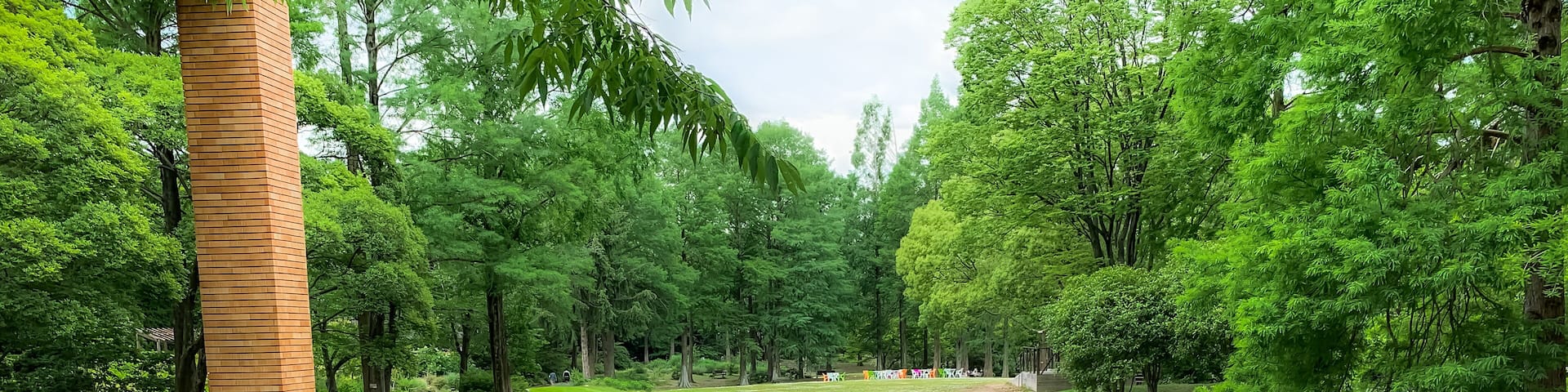 Un parque tranquilo con un estanque, un pabellón de madera y un césped bien cuidado.