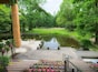 Un parc paisible avec un étang, un pavillon en bois et une pelouse bien entretenue.