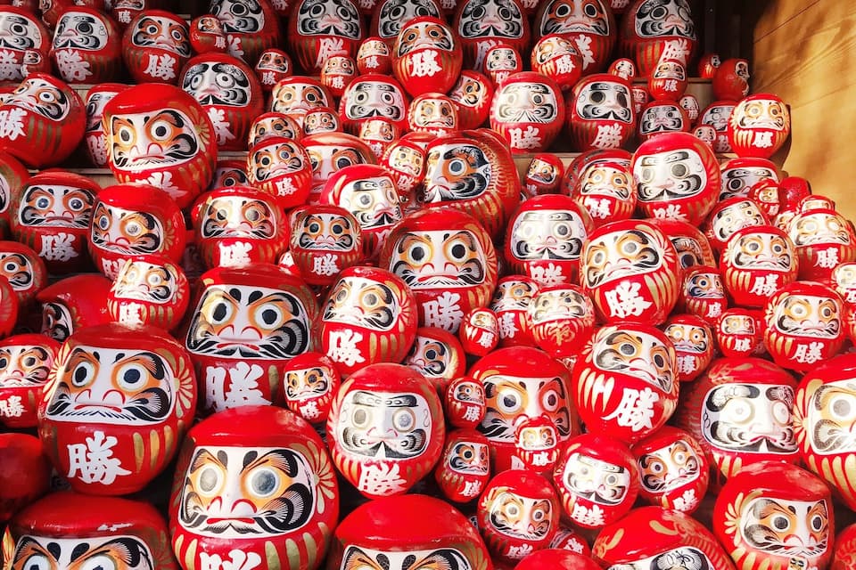 A collection of red and white painted wooden dolls.