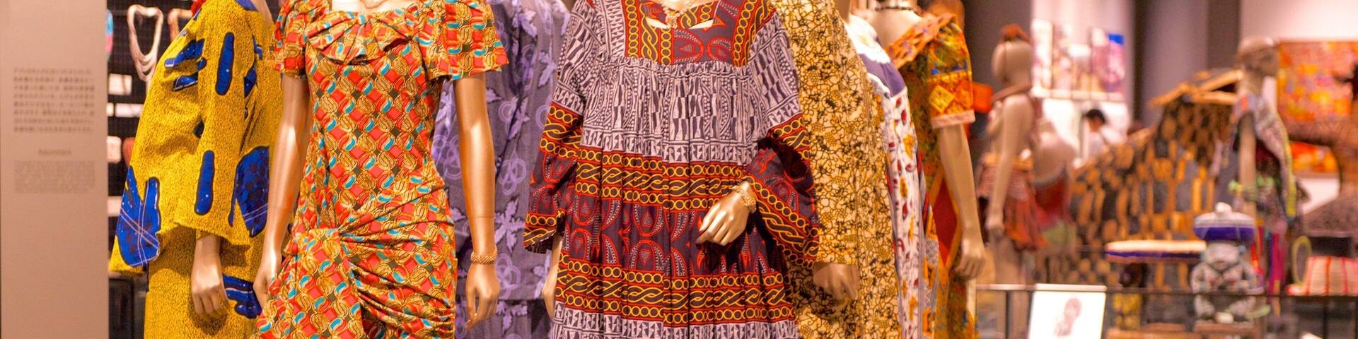 Mannequins displaying colorful traditional dresses in a museum.