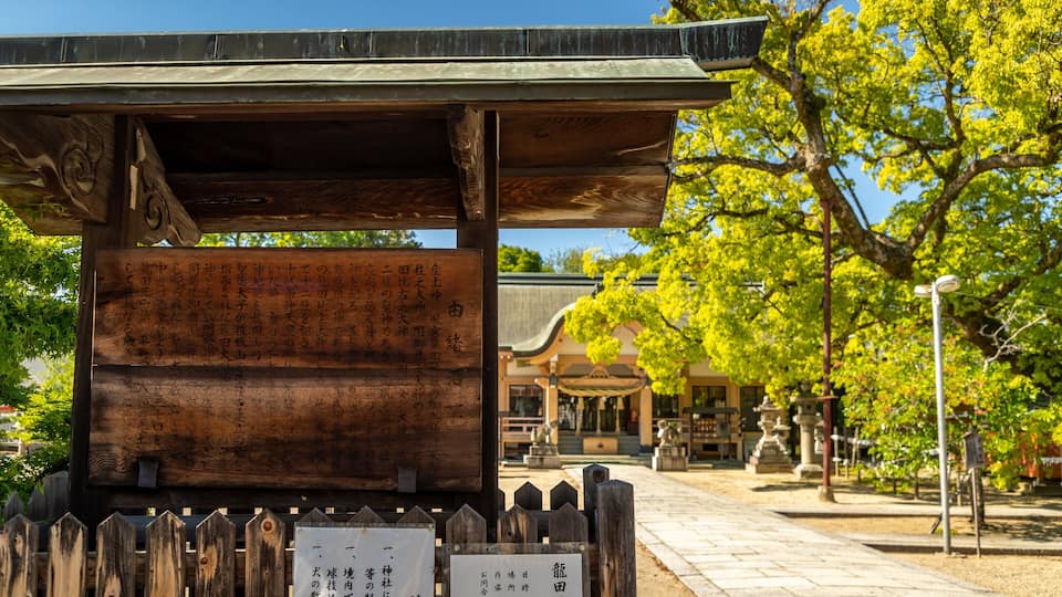 Uma estrutura tradicional japonesa de madeira com uma placa em frente.