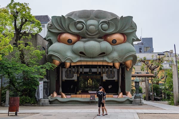 Namba Yasaka Shrine featuring street scenes and outdoor art as well as a couple