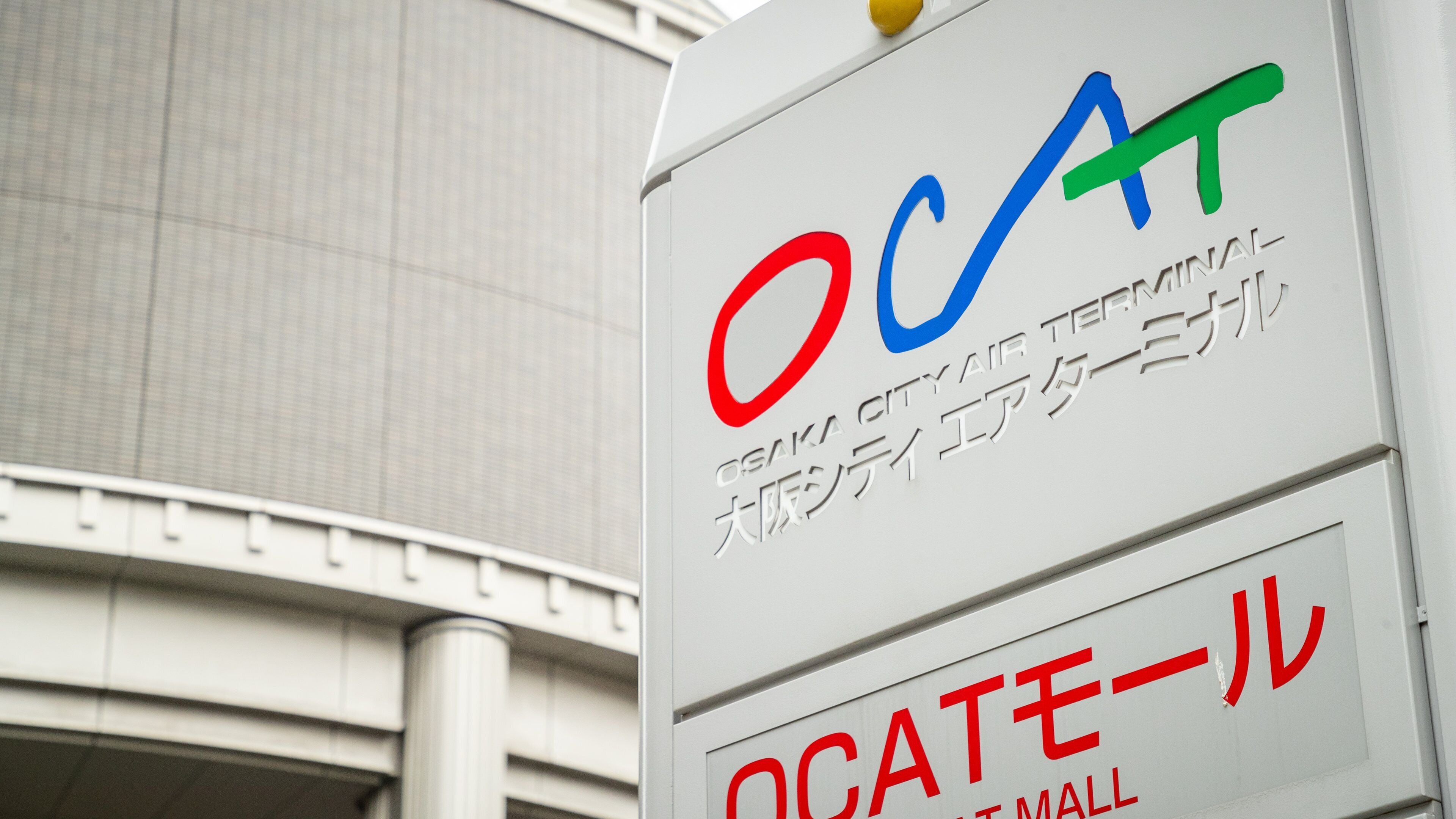 En skylt med bokstäverna ”OCA” och ”OSAKA CITY AIR TERMINAL” på både engelska och japanska.