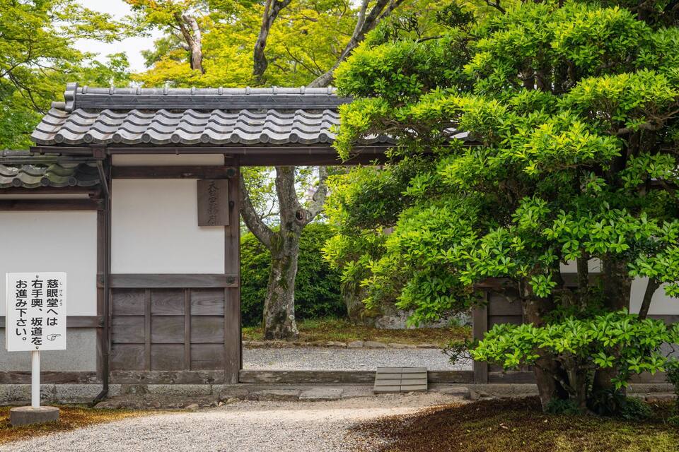 Un edificio tradicional japonés con techo de tejas y un letrero con caracteres japoneses.