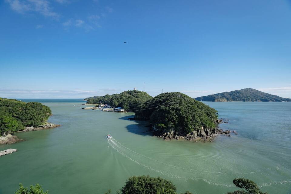 A river with boats, a bridge, and green islands.