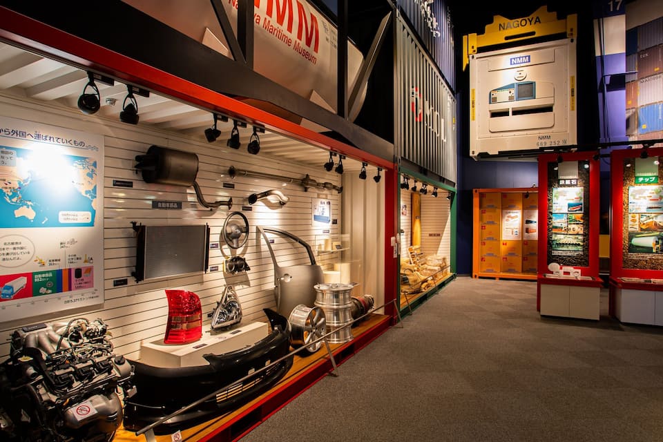 A maritime museum with exhibits including ship wheels, a ship's engine, and shipping containers.