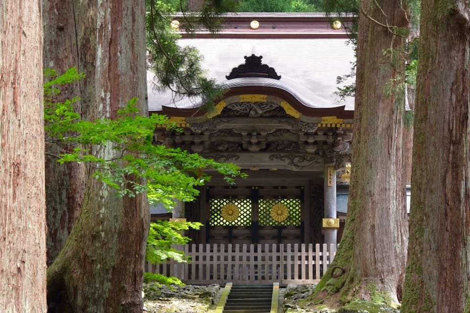 Un bâtiment traditionnel japonais entouré de grands arbres.
