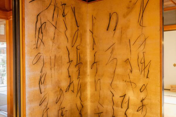 A room with a wooden interior and a large, open cabinet with black calligraphy on the inside.