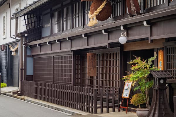 Un bâtiment traditionnel japonais doté de fenêtres à croisillons en bois et d’une enseigne.