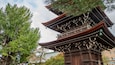 A traditional Japanese pagoda with multiple tiers, surrounded by lush green trees.