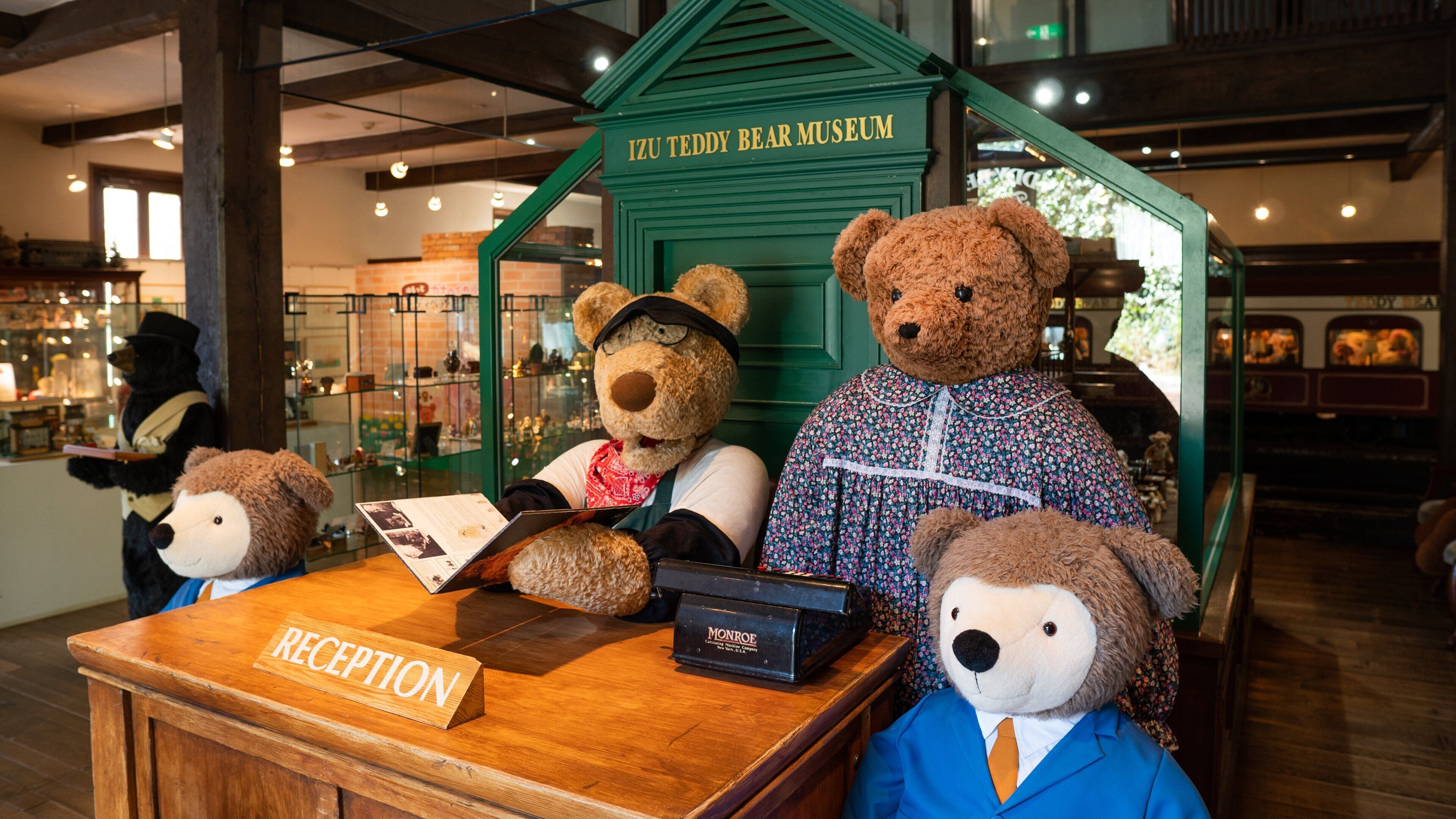 Un museo con una recepción y osos de peluche vestidos con diferentes atuendos.