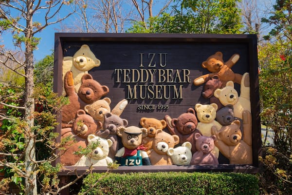 Placa para o Museu dos Ursos de Pelúcia de Izu, com diversos ursos de pelúcia em exposição.