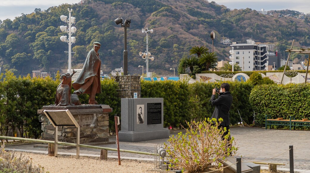 Omiya’s Pinetree / Statue of Kanichi and Omiya featuring a statue or sculpture as well as an individual male