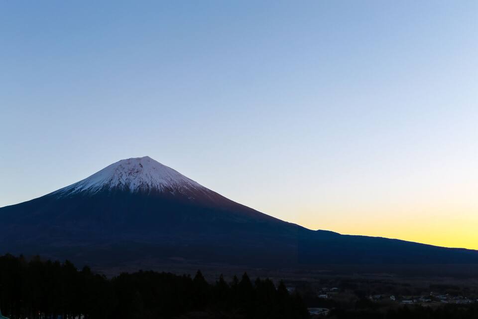 A snow-capped mountain at sunrise or sunset.