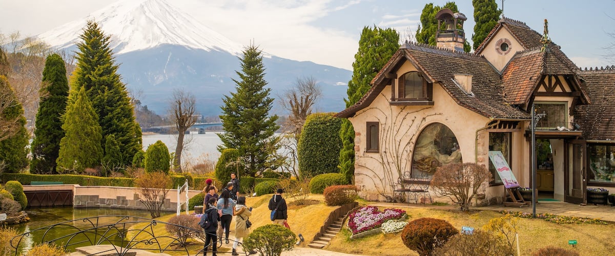 Kawaguchiko Music Forest Museum featuring a pond and a bridge as well as a small group of people