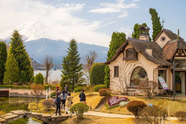 Kawaguchiko Music Forest Museum featuring a pond and a bridge as well as a small group of people