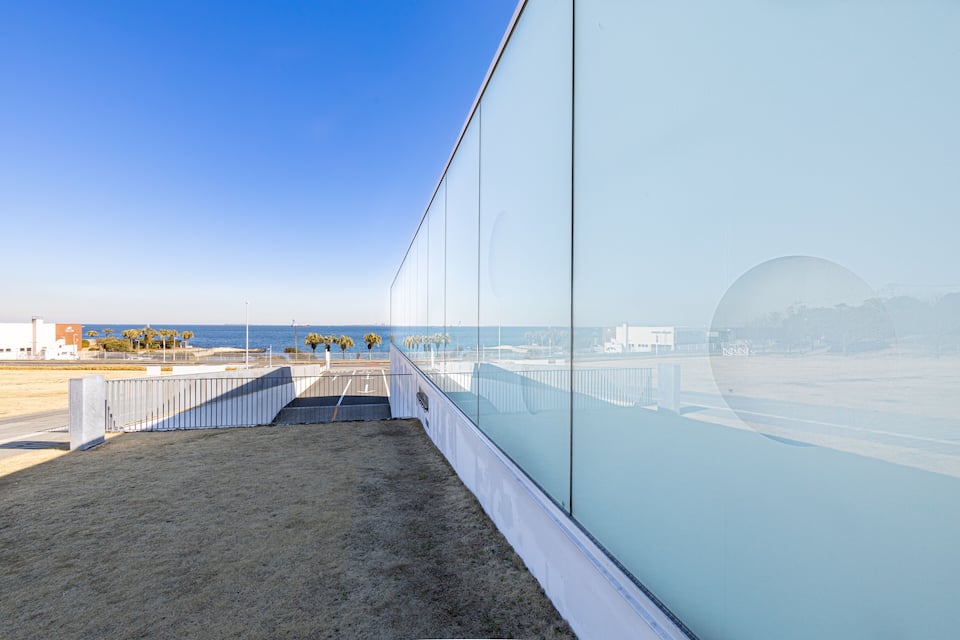 Une promenade en bord de mer offrant une vue dégagée sur l’océan et les bâtiments situés au loin.