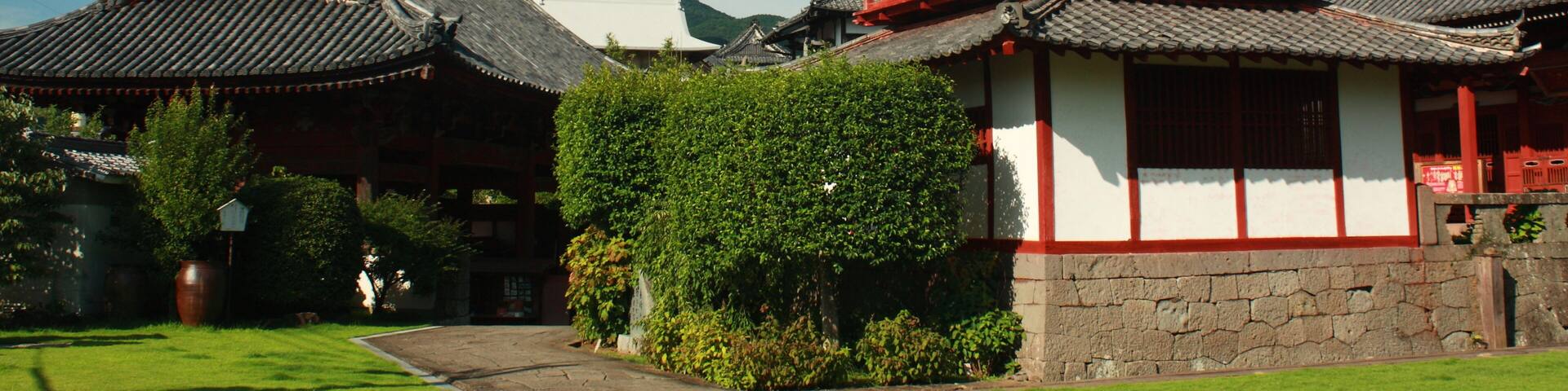 A traditional Korean temple with a prominent red and white structure, surrounded by lush greenery and traditional architecture.