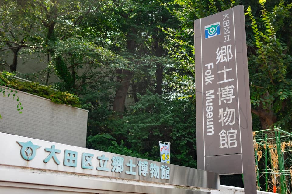 A sign for the Fukuoka Museum with Chinese characters and a logo.