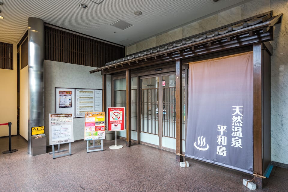 A traditional Japanese building entrance with signage and a tiled floor.