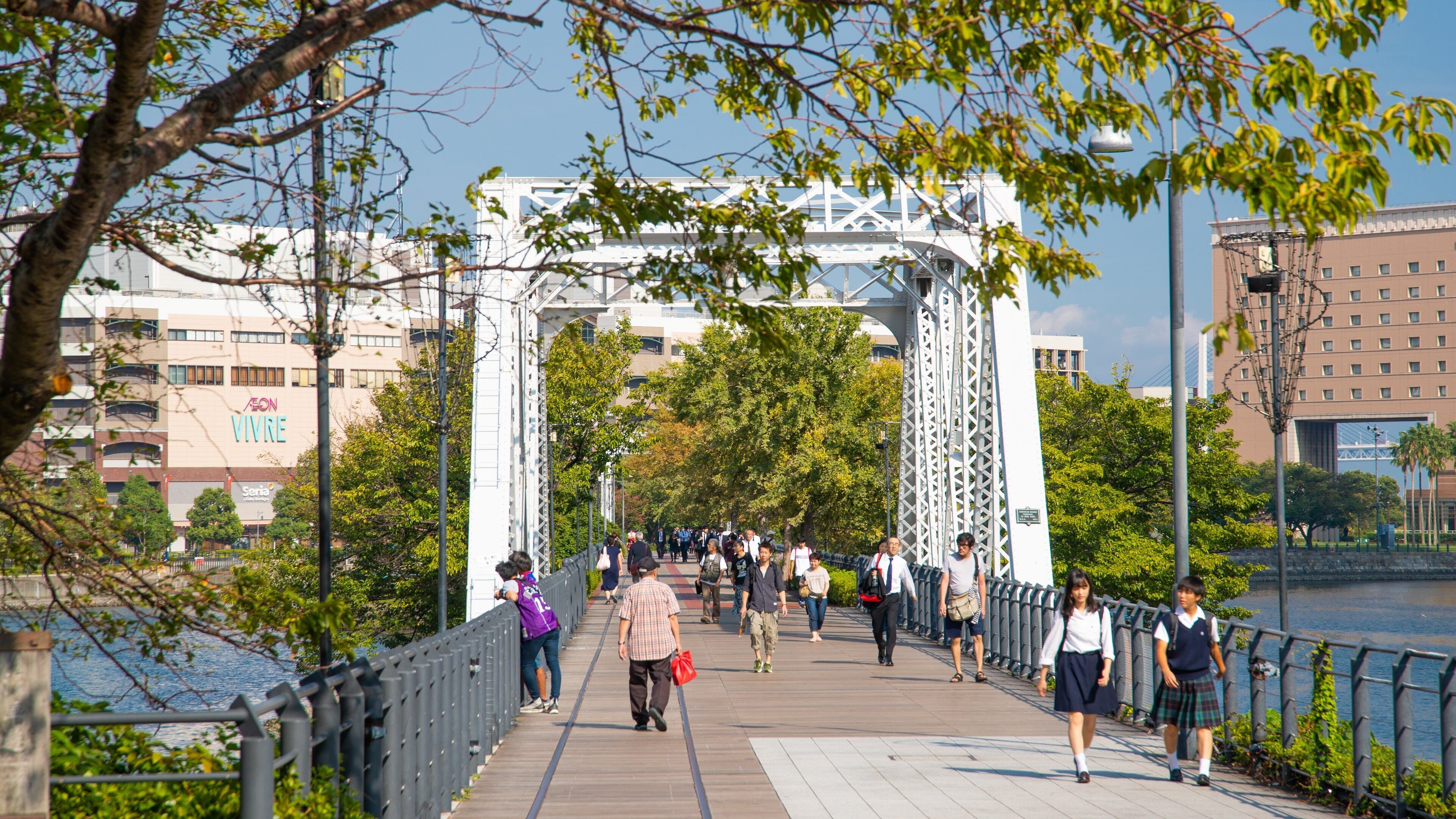 Walkers enjoying a sunny day at Gotoh Museum park in Yokohama, Japan, with lush greenery and bright blue skies
