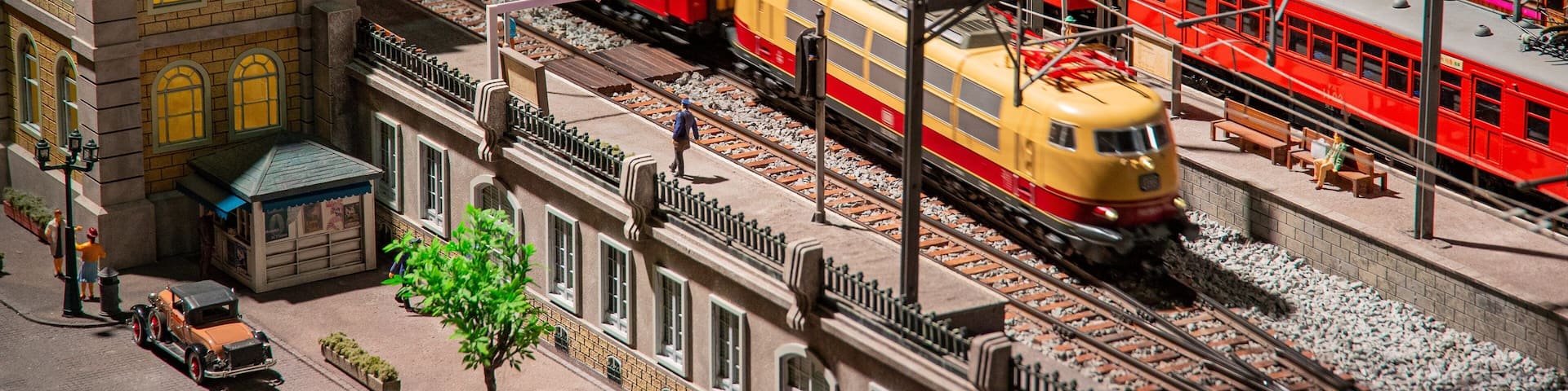 A detailed model of a train station with multiple tracks, trains, and miniature buildings.