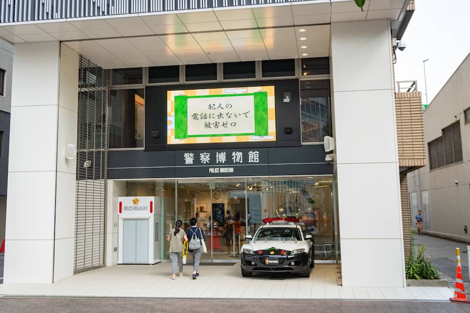 A police museum with a white car parked in front.