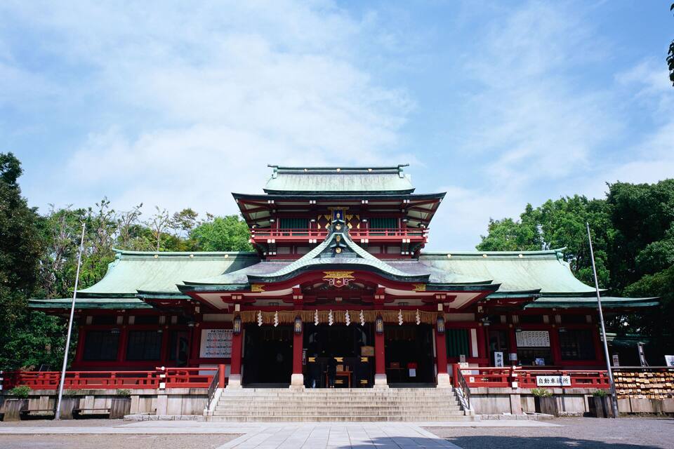 Un templo japonés tradicional con un tejado de varios niveles y detalles en rojo y verde.
