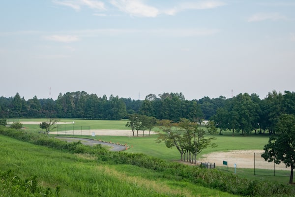 Ein Golfplatz mit gepflegtem Grün, Sandbunkern und blauem Himmel.