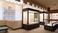 A museum interior with glass display cases and wall-mounted exhibits.