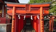 Un tradicional torii japonés con pilares rojos y un cartel.