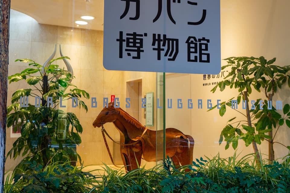 Ein Museumszeichen mit einer Pferdestatue und Grünpflanzen.