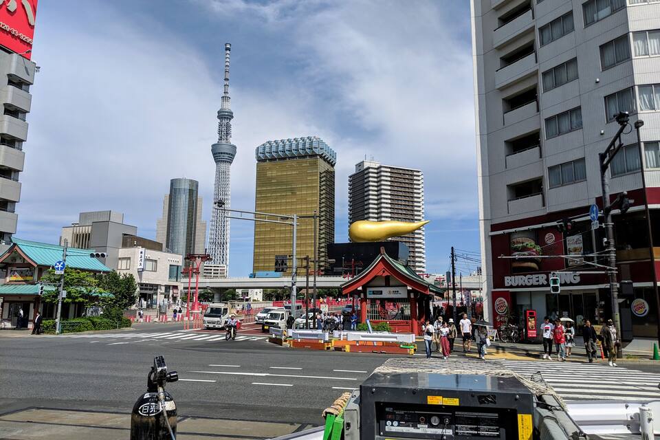 A busy urban street with a prominent tower, a Burger King, and traditional architecture.