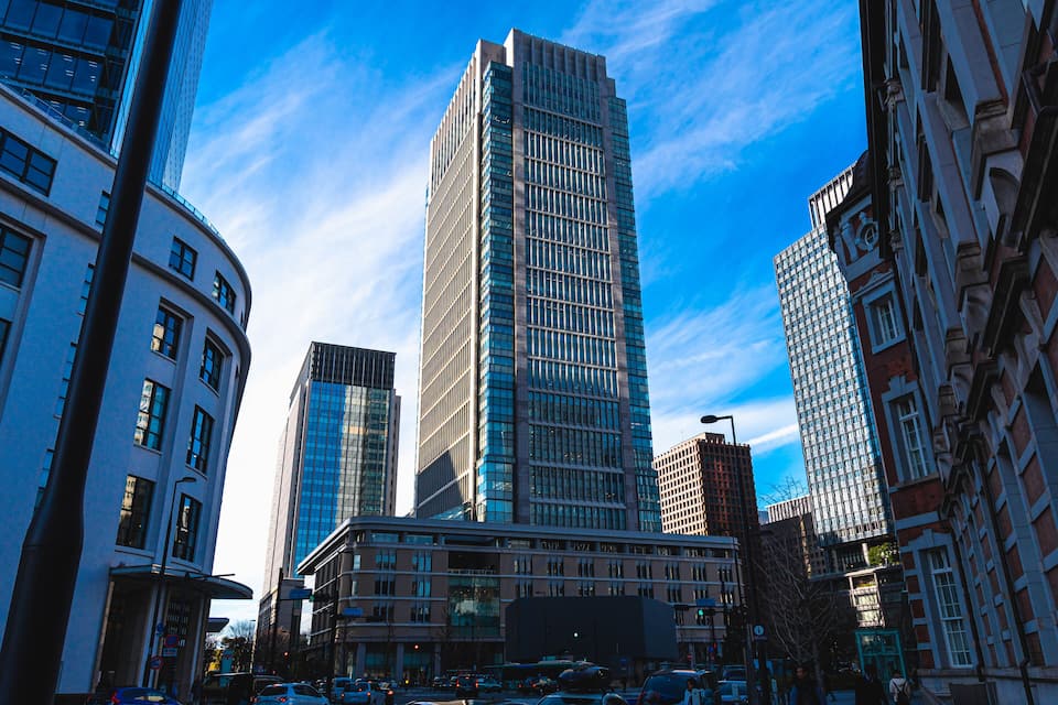 Een stadsgezicht met hoge gebouwen, waaronder een opvallend wolkenkrabber met reflecterende glazen ramen.